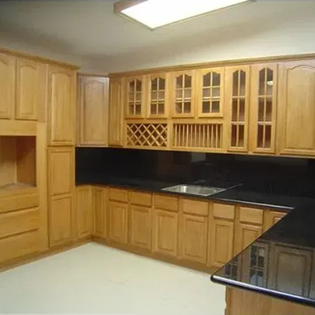 Kitchen with honey oak cabinets, glass-front uppers, a built-in wine rack and black countertops