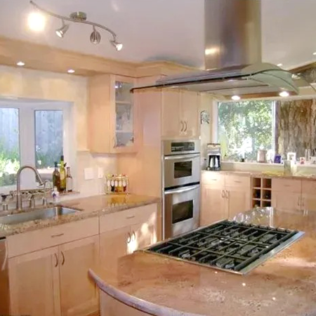 Kitchen with light maple cabinets, granite countertops, a gas cooktop island and track lighting