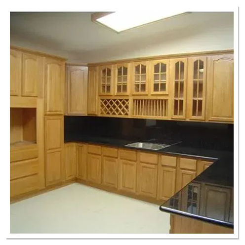L-shaped kitchen with honey oak cabinets, glass-front uppers, a built-in wine rack and black countertops
