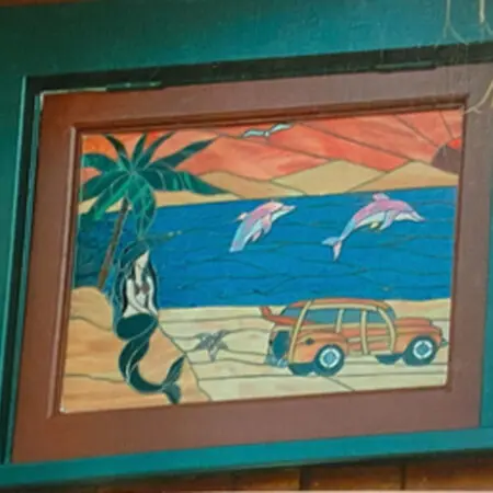 Custom stained-glass window with dolphins, a mermaid and a woodie car on the beach